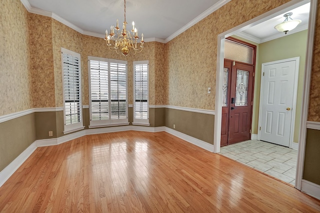 entryway with ornamental molding, an inviting chandelier, and light wood-type flooring