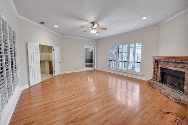 unfurnished living room with a brick fireplace, crown molding, light hardwood / wood-style floors, and ceiling fan