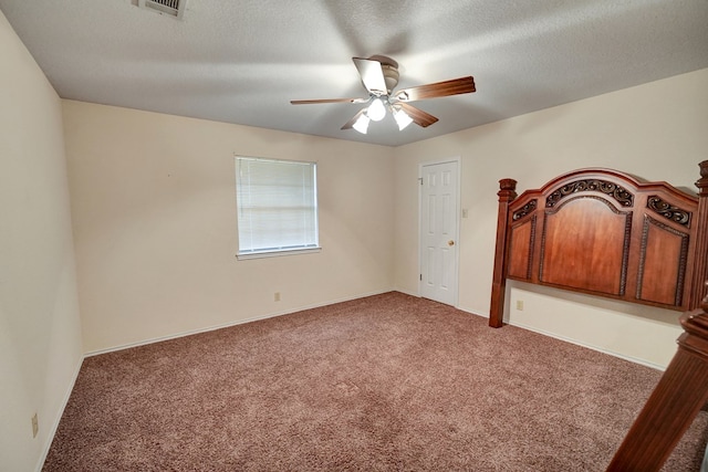 unfurnished bedroom featuring ceiling fan, carpet, and a textured ceiling