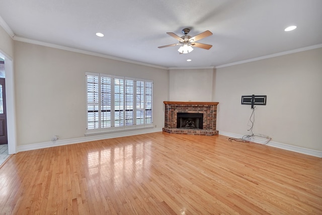 unfurnished living room with ornamental molding, ceiling fan, a fireplace, and light hardwood / wood-style floors