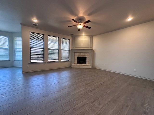 3210 Fordham Ave, Big Spring, TX 79720 - unfurnished living room with a ceiling fan, dark wood finished floors, and a stone fireplace