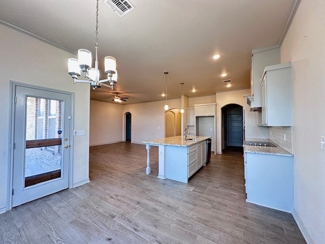 3210 Fordham Ave, Big Spring, TX 79720 - kitchen featuring arched walkways, open floor plan, a chandelier, dishwasher, and white cabinetry