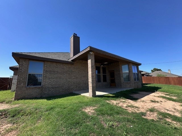 3210 Fordham Ave, Big Spring, TX 79720 - rear view of house featuring a chimney, a patio area, and brick siding