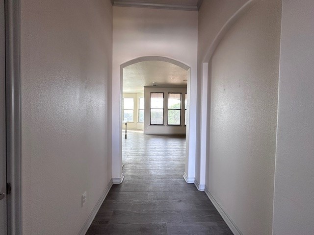 3210 Fordham Ave, Big Spring, TX 79720 - hallway with arched walkways and dark wood-type flooring