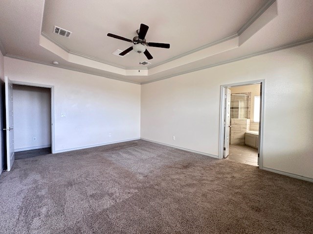 3210 Fordham Ave, Big Spring, TX 79720 - unfurnished bedroom with a tray ceiling, ornamental molding, carpet, ensuite bathroom, and ceiling fan