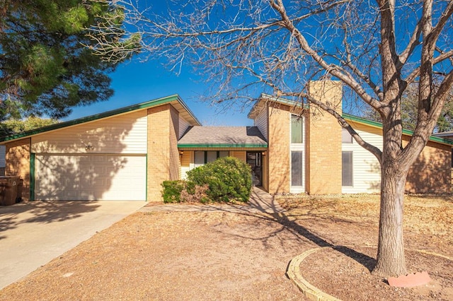 view of front of house featuring a garage, driveway, brick siding, and a chimney