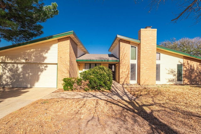 mid-century inspired home featuring a garage, concrete driveway, brick siding, and a chimney