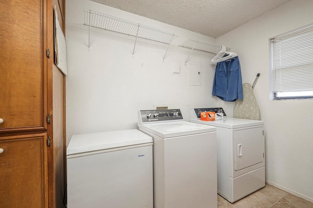 laundry room with laundry area, washing machine and dryer, and a textured ceiling