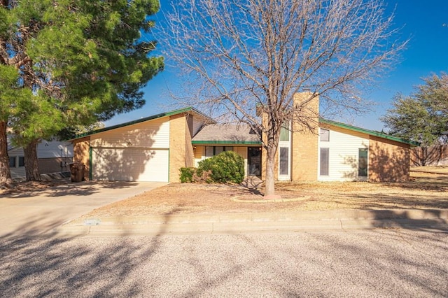 mid-century modern home featuring a garage, concrete driveway, and a chimney