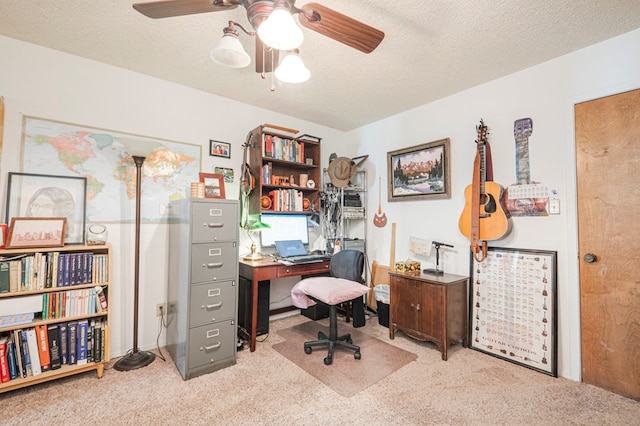 home office featuring a textured ceiling, a ceiling fan, and light colored carpet