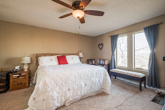 carpeted bedroom with ceiling fan and a textured ceiling
