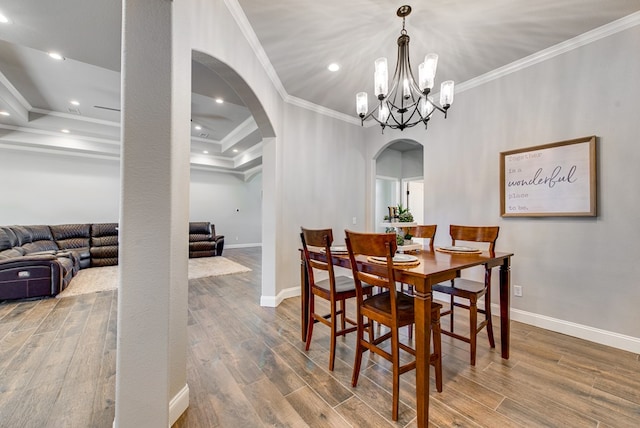 dining space with wood finished floors, baseboards, recessed lighting, arched walkways, and ornamental molding