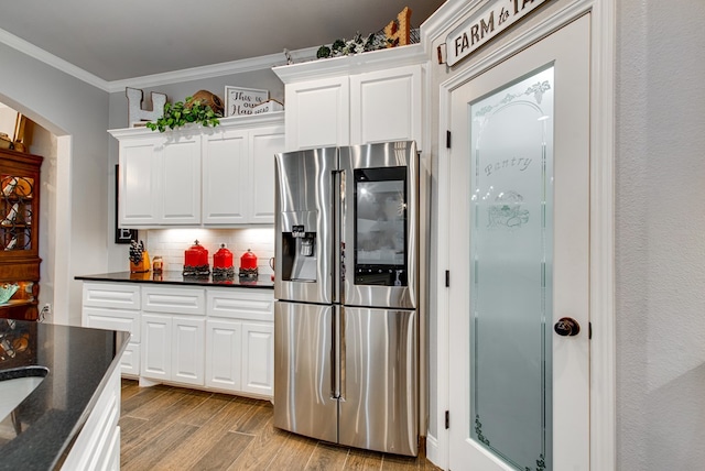 kitchen with wood finished floors, decorative backsplash, stainless steel refrigerator with ice dispenser, white cabinetry, and crown molding