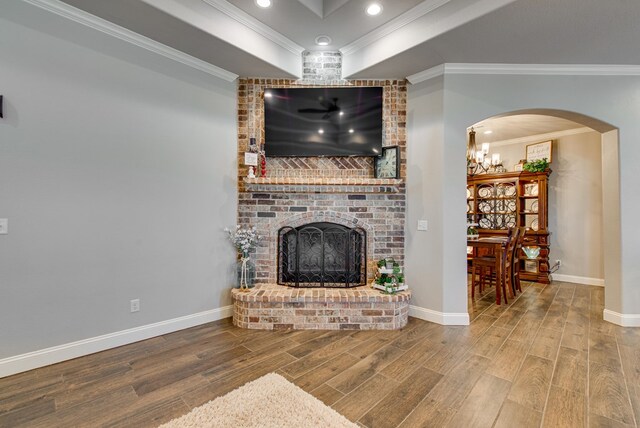 1602 S County Rd 1069, Midland, TX 79706 - living room featuring crown molding, wood finished floors, a brick fireplace, baseboards, and arched walkways