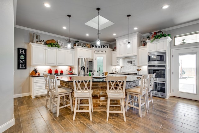 kitchen with stainless steel appliances, wood finished floors, and crown molding