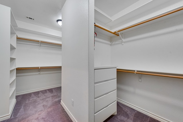 walk in closet with visible vents and dark carpet