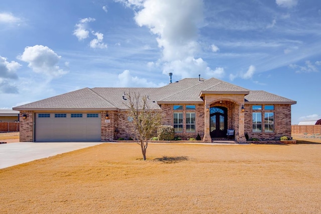 view of front of property featuring brick siding, concrete driveway, an attached garage, and fence