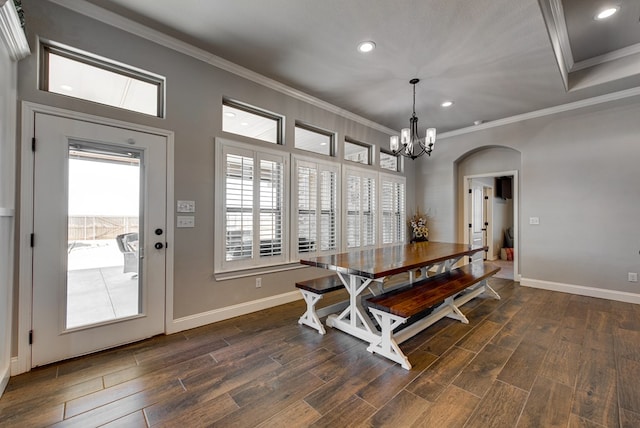 dining room featuring a chandelier, dark wood-type flooring, baseboards, and ornamental molding