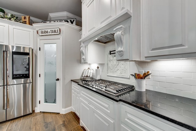 1602 S County Rd 1069, Midland, TX 79706 - kitchen featuring stainless steel appliances, decorative backsplash, white cabinets, dark wood finished floors, and dark stone countertops
