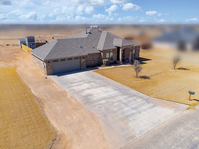 view of front of property featuring brick siding, an attached garage, a shingled roof, and concrete driveway