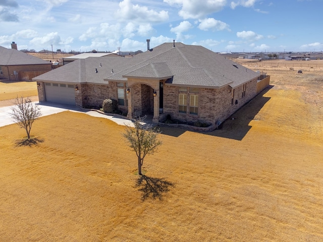 view of front of house with brick siding, concrete driveway, a shingled roof, and a garage