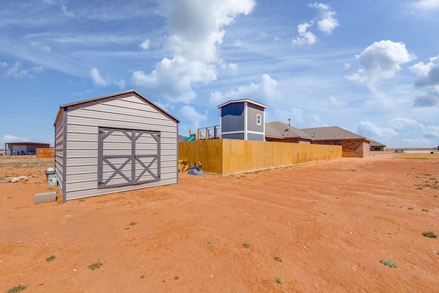 view of yard with an outdoor structure, a storage unit, and fence