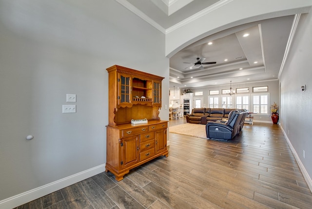 1602 S County Rd 1069, Midland, TX 79706 - living room with a ceiling fan, a raised ceiling, dark wood-style flooring, arched walkways, and crown molding