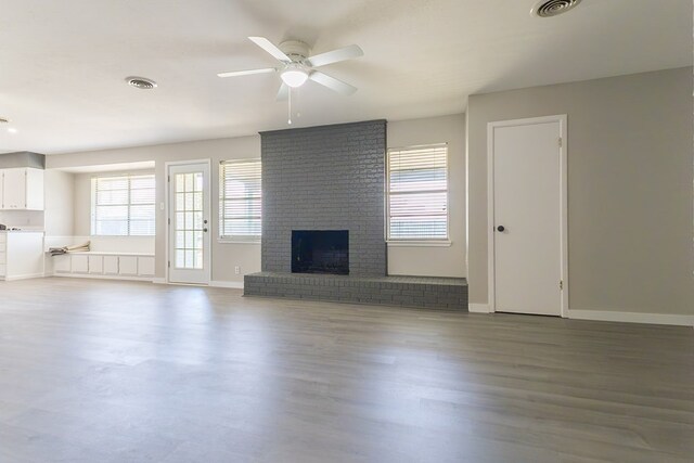 3319 Maxwell Dr, Midland, TX 79705 - unfurnished living room featuring a ceiling fan, a brick fireplace, and wood finished floors