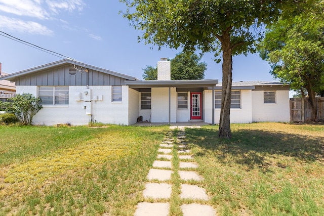 3319 Maxwell Dr, Midland, TX 79705 - ranch-style house with a chimney, brick siding, board and batten siding, and a porch