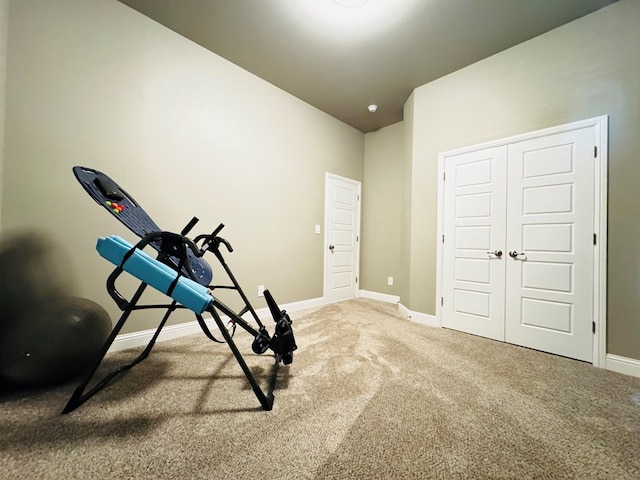 exercise room with baseboards and carpet