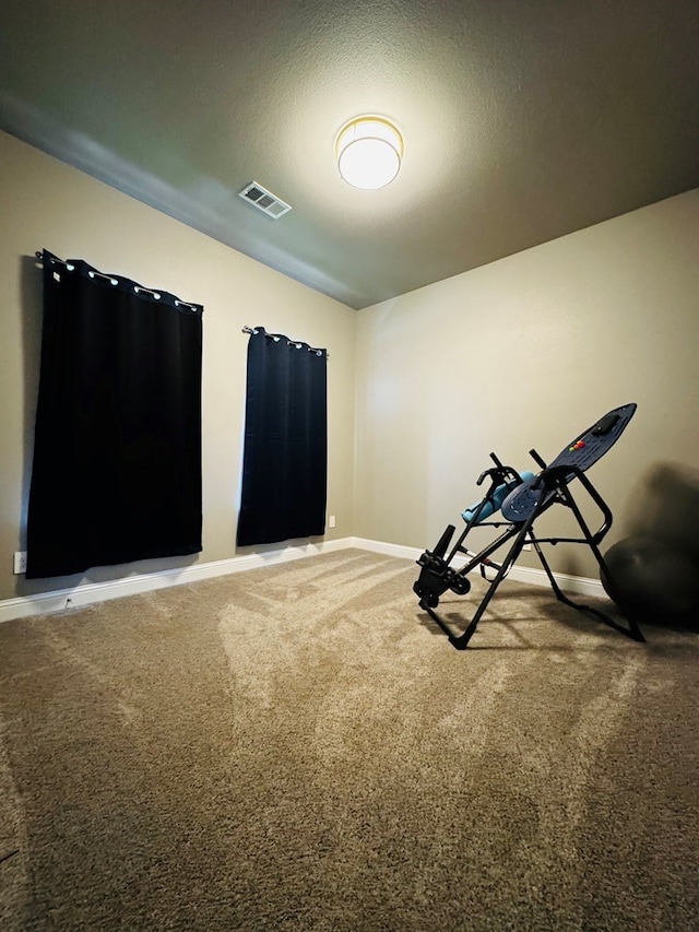 exercise room with visible vents, carpet floors, a textured ceiling, and baseboards