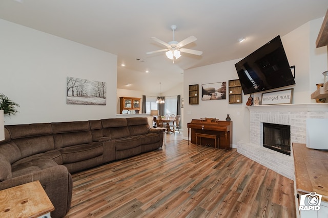 living room featuring a brick fireplace, ceiling fan, lofted ceiling, and hardwood / wood-style flooring