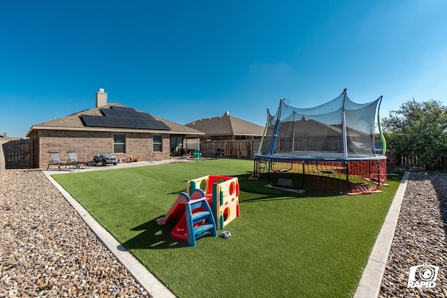 view of home's community with a lawn, a patio area, and a trampoline