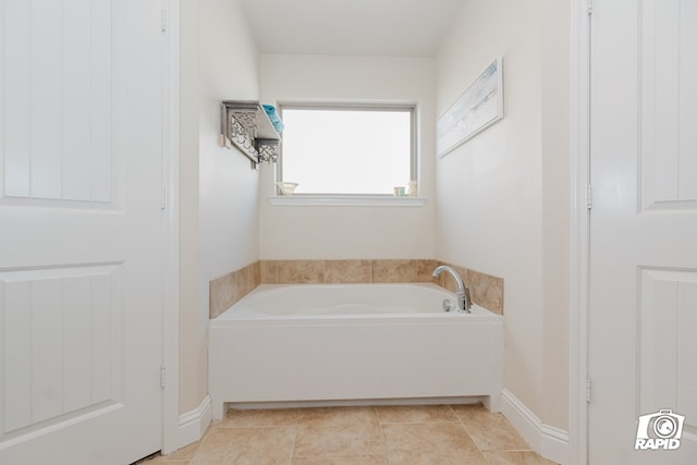 bathroom with a washtub and tile patterned floors