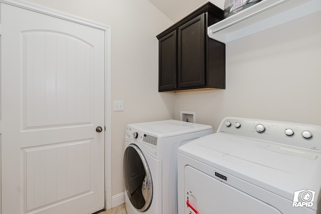 laundry room with washer and dryer and cabinets