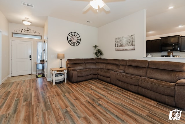 living room with dark hardwood / wood-style floors and ceiling fan