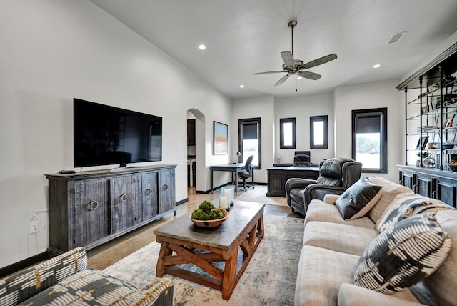 living area with arched walkways, recessed lighting, ceiling fan, a desk, and baseboards