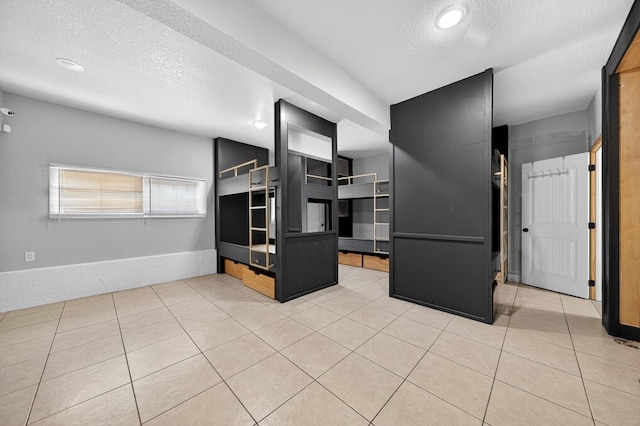 2502 W Cuthbert Ave, Midland, TX 79701 - unfurnished living room with a textured ceiling and light tile patterned floors