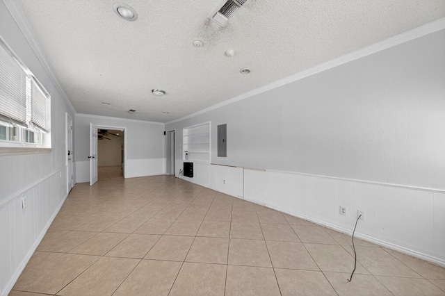 2502 W Cuthbert Ave, Midland, TX 79701 - unfurnished living room featuring crown molding, a textured ceiling, light tile patterned floors, built in shelves, and electric panel
