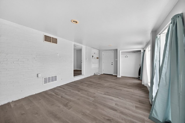 2502 W Cuthbert Ave, Midland, TX 79701 - empty room featuring wood finished floors and brick wall