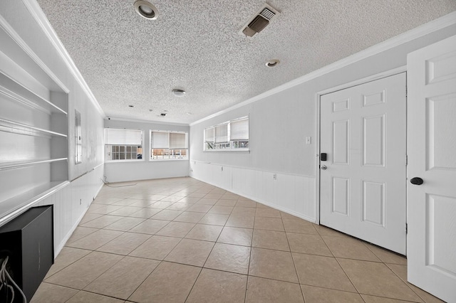 2502 W Cuthbert Ave, Midland, TX 79701 - unfurnished room featuring crown molding, a textured ceiling, light tile patterned floors, built in features, and a wainscoted wall