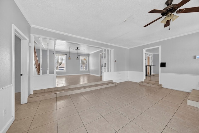 2502 W Cuthbert Ave, Midland, TX 79701 - spare room with light tile patterned floors, a ceiling fan, a textured ceiling, wainscoting, and crown molding