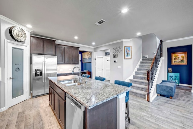 806 Revere Pl, Midland, TX 79706 - kitchen with a kitchen breakfast bar, visible vents, crown molding, a sink, and stainless steel appliances