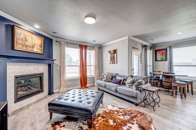 806 Revere Pl, Midland, TX 79706 - living area featuring crown molding, a textured ceiling, visible vents, and light wood-style floors