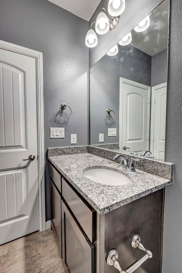 806 Revere Pl, Midland, TX 79706 - bathroom featuring vanity, a textured wall, baseboards, and wood finished floors