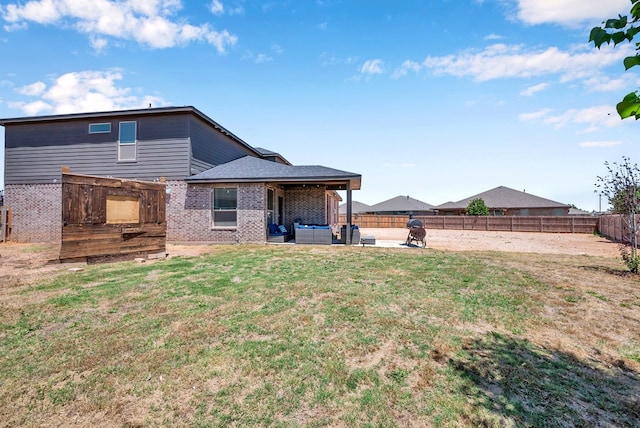 806 Revere Pl, Midland, TX 79706 - back of property featuring brick siding, a fenced backyard, an outdoor living space, a patio area, and a yard