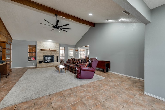 tiled living room with high vaulted ceiling, beamed ceiling, ceiling fan, a brick fireplace, and a textured ceiling