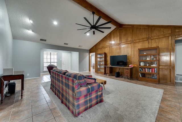 tiled living room featuring built in features, ceiling fan, high vaulted ceiling, beamed ceiling, and wood walls