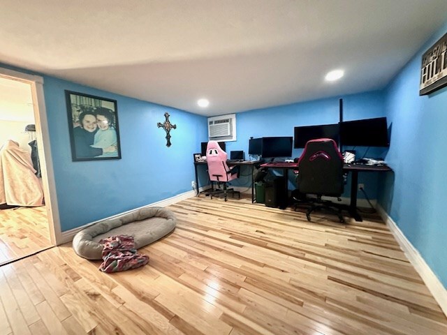 office space featuring a wall mounted AC and hardwood / wood-style floors