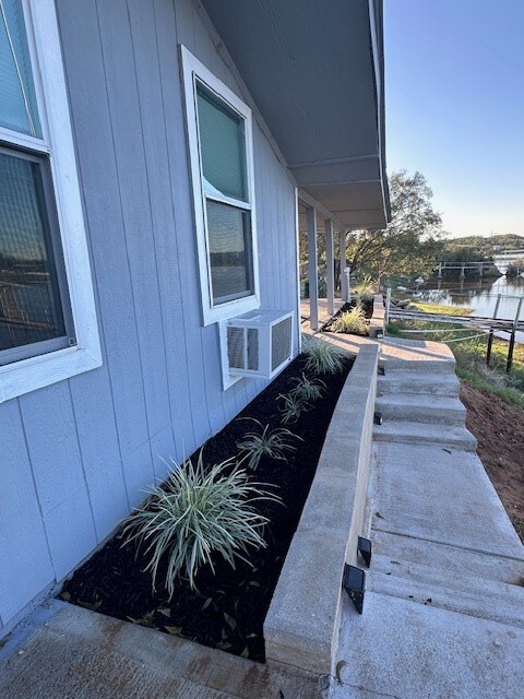 view of side of home with a water view and cooling unit